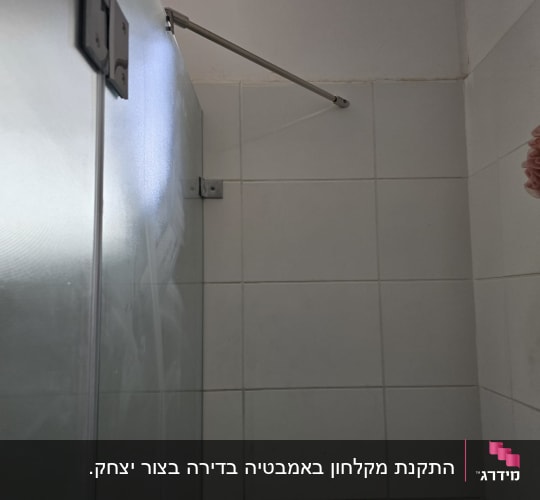 מקלחון עם דלת זכוכית ומוט מתכת